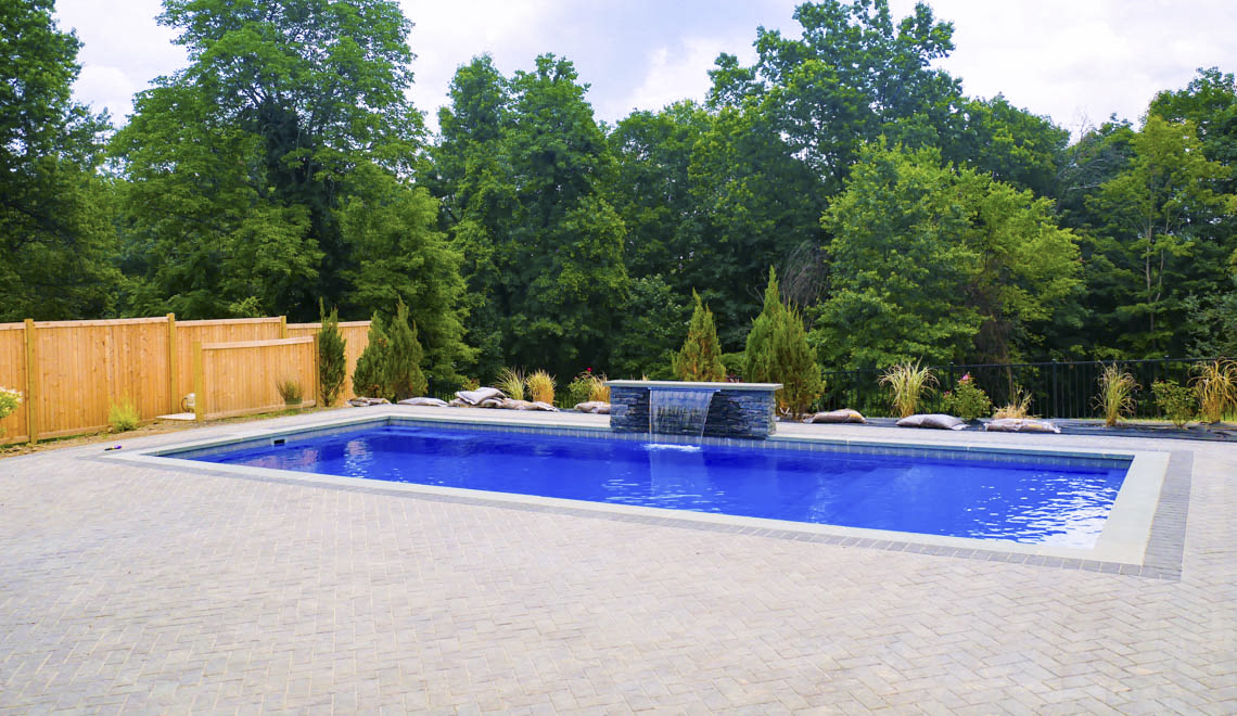 Leisure Pools Pinnacle large fiberglass swimming pool with built-in splash deck