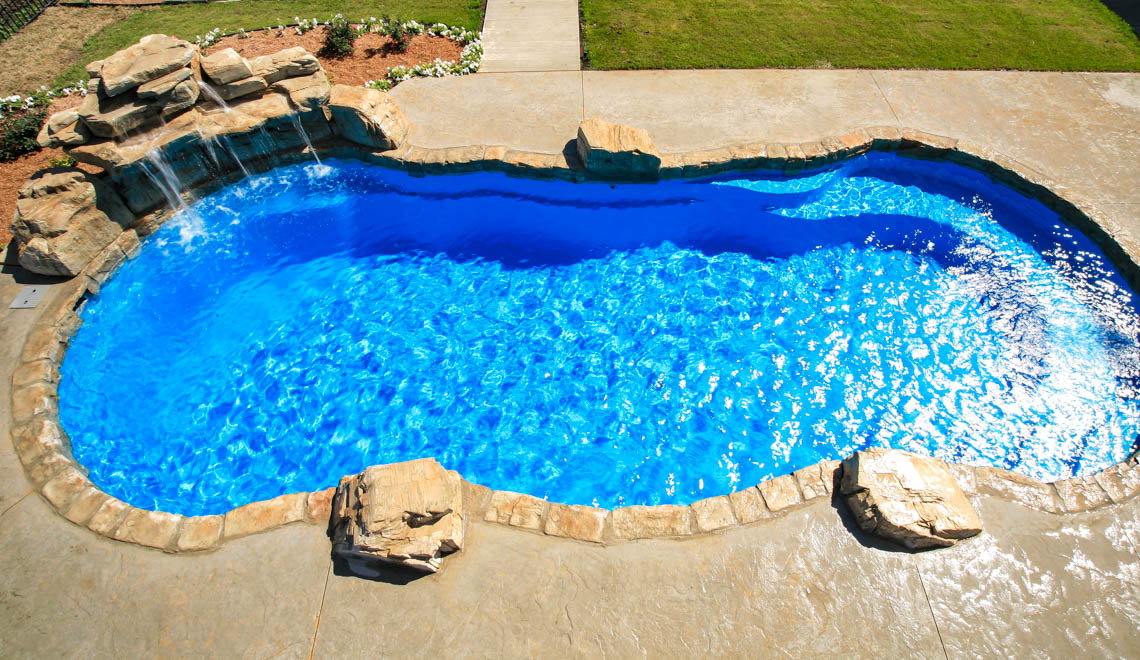 Leisure Pools Riviera composite fiberglass freeform swimming pool with perimeter safety ledge