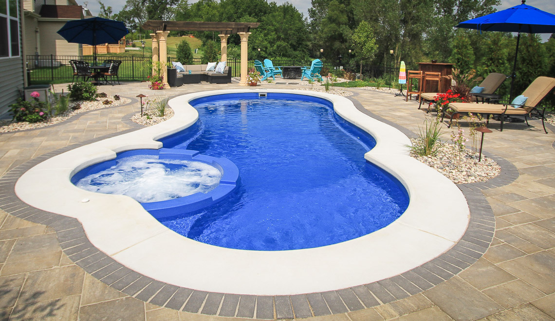 Leisure Pools Allure large fiberglass swimming pool with built-in spa and splash deck