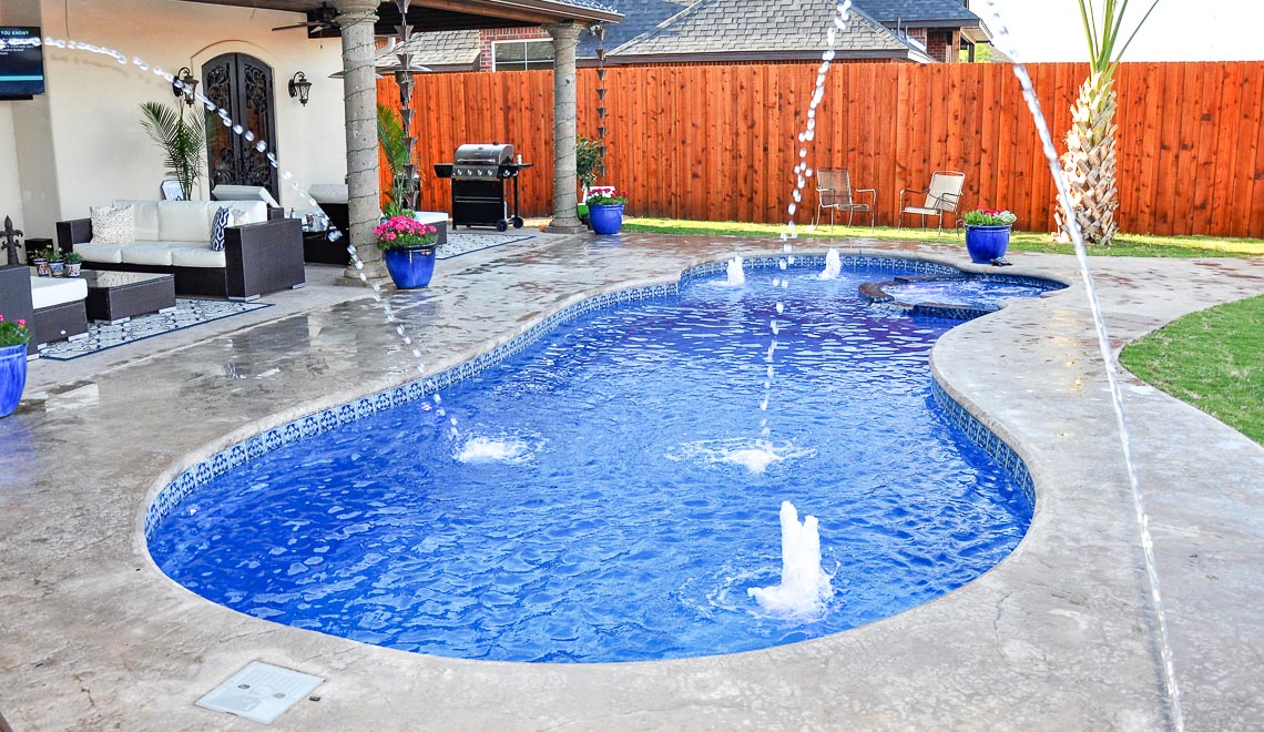Leisure Pools Allure large freeform swimming pool with built-in spa and splash deck