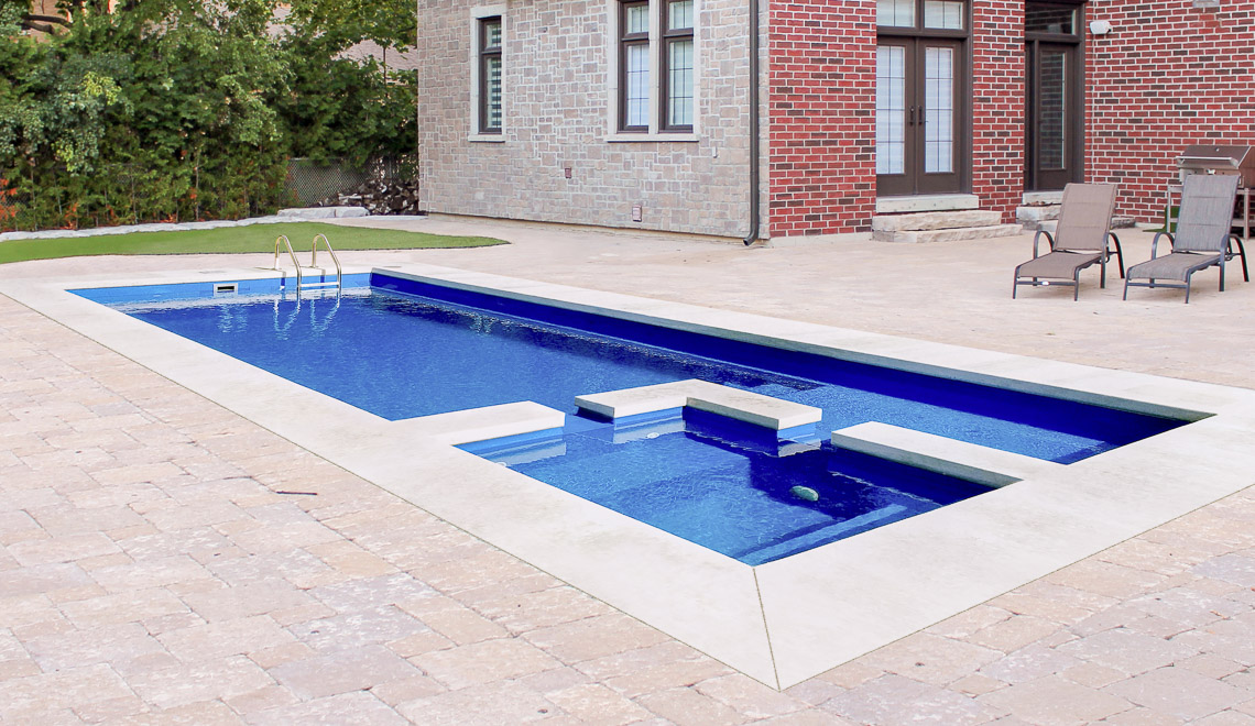 Leisure Pools Limitless composite fiberglass swimming pool with built-in spa, splash deck and bench